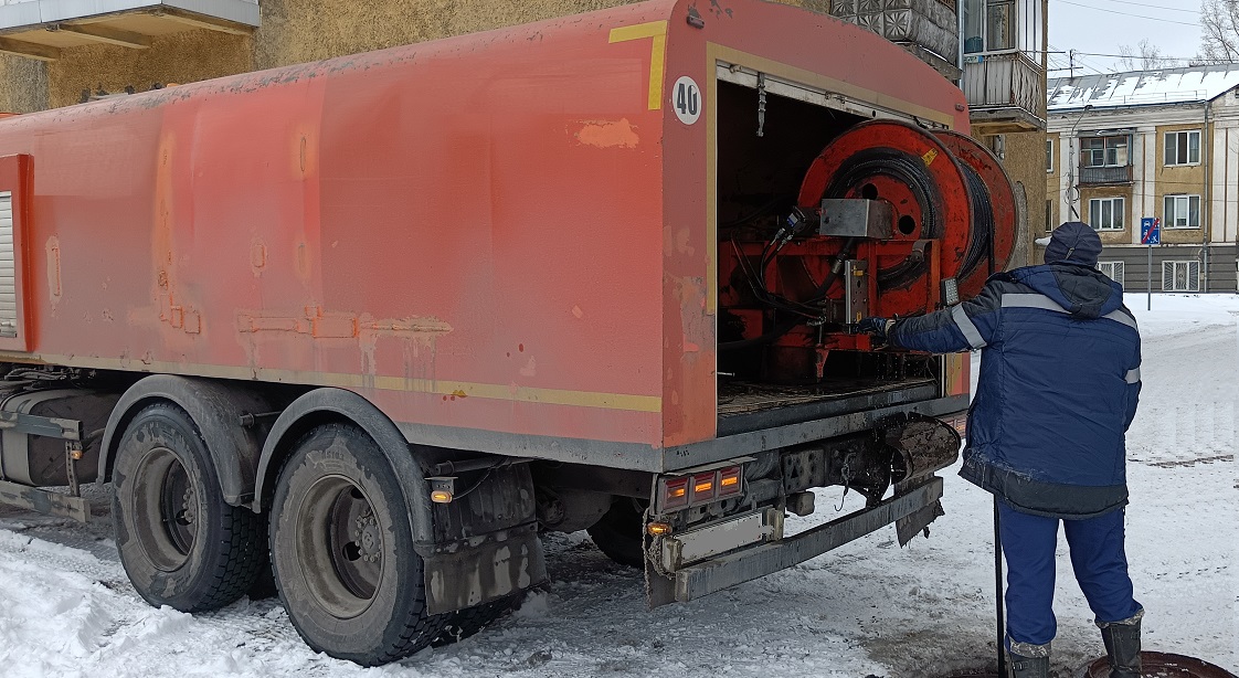 Каналопромывочная машина и работник прочищают засор в канализационной системе в Тээли